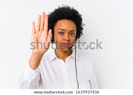 Young african american telemarketer woman isolated standing with outstretched hand showing stop sign, preventing you.