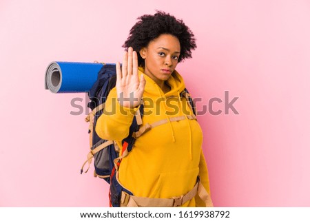 Young african american backpacker woman isolated standing with outstretched hand showing stop sign, preventing you.