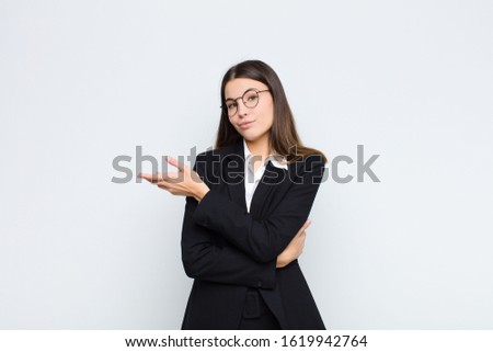 young businesswoman feeling confused and clueless, wondering about a doubtful explanation or thought against white wall