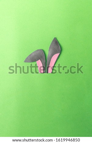 abstract image of easter bunny ears sticking their burrows on a green background