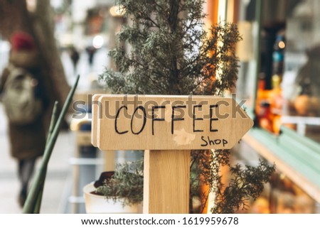 Sign coffee shop with a pointer on the street.