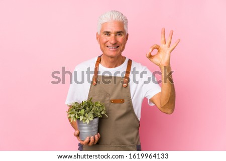 Middle aged gardener man isolated cheerful and confident showing ok gesture.