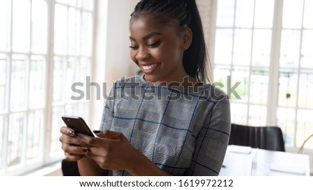 Close up of smiling african American businesswoman hold cellphone browsing wireless unlimited fast internet, happy biracial woman employee using smartphone, check mail on new cellular device Royalty-Free Stock Photo #1619972212