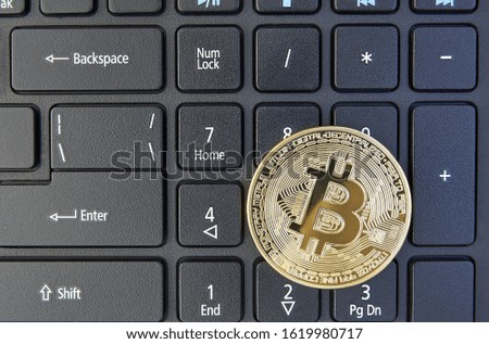 Bitcoin coin lies on a black laptop keyboard .digital currency, bitcoin. cryptocurrency and financial market. money and commerce