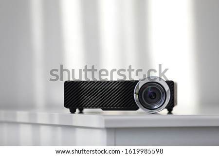 Modern video projector on white table indoors