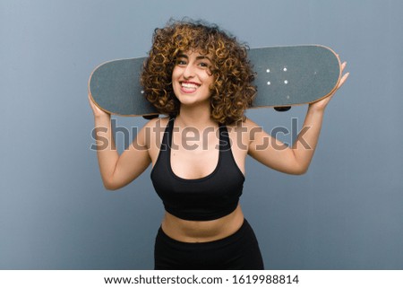 young pretty sports woman wearing fitness clothes with a skate