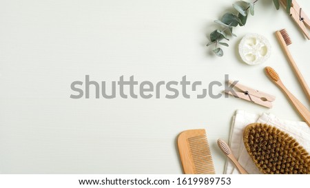 Zero waste bathroom accessories on green table. Top view bath peeling brush, wooden hair comb, bamboo toothbrushes, luffa sponge, towel. Eco-friendly bath products, beauty and SPA treatment concept Royalty-Free Stock Photo #1619989753