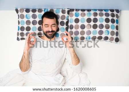 Man in bed in top view in zen pose