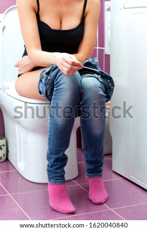 woman using pregnancy test in a toilet