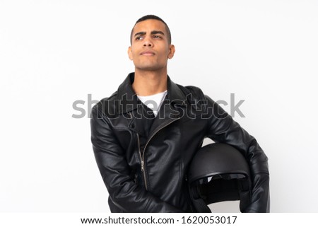 Young handsome man with a motorcycle helmet over isolated white background standing and looking to the side