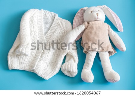 Knitted baby clothes and accessories on a blue background . The view from the top