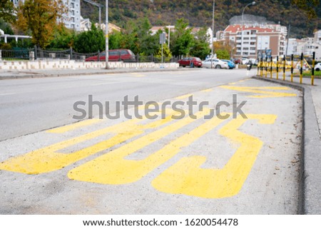 The special place for bus stop with yellow inscription on asphalt. City view background, outdoors.
