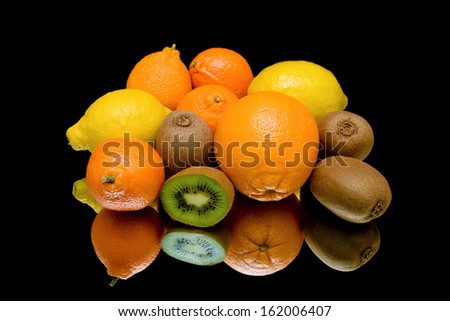 fresh juicy fruits on a black background close up with reflection. horizontal photo.