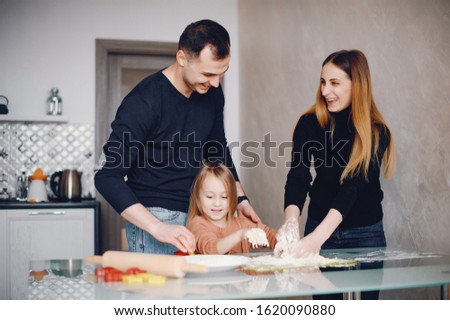 Family in a kitchen. Little girl with a dough.