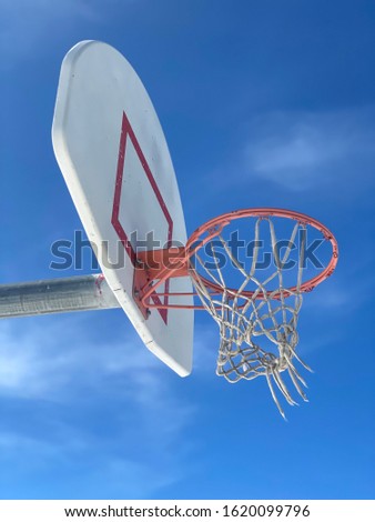 Basketball whiteboard with torn net in blue sky