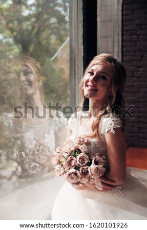 bride sits near a large window