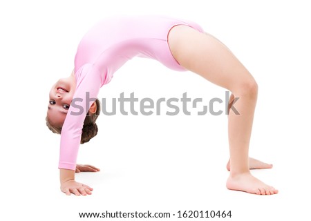 Small positive girl in pink gymnastic jumpsuit standing in bridge pose and smiling over white background. Active healthy lifestyle, hobbies and sporty children concept