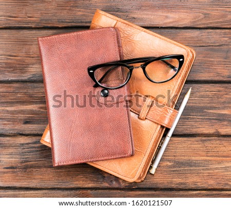 Notebooks and pen on wooden table