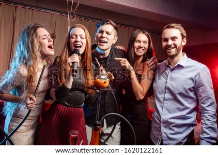 young people celebrating birthday in karaoke bar, singing and smoking hookah. leisure time, happy positive pastime
