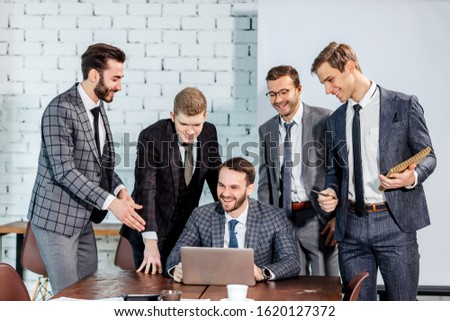 happy smiling business team work together in office, using modern laptop, men in tuxedo coworking. business people concept