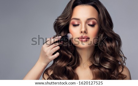 Makeup artist applies   applies powder and blush  . Beautiful woman face. Hand of make-up master puts blush on cheeks  beauty  model girl . Make up in process Royalty-Free Stock Photo #1620127525