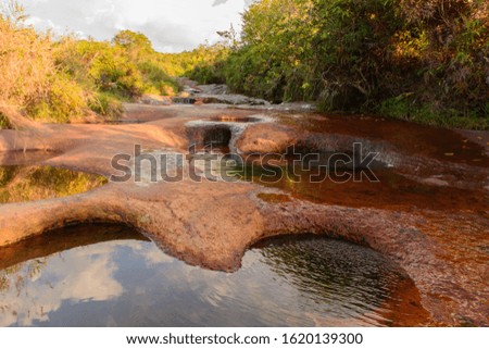 river with reddish stone hollows