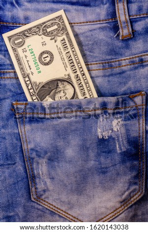 American one dollar banknote in pocket of blue jeans