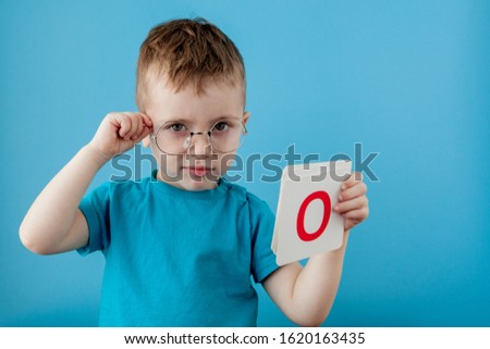 Cute little boy with letter on blue background. Child learning a letters. Alphabet.