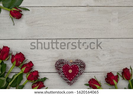 Romantic background, white wooden planks with natural red roses and red decorative heart for concepts, posters or design.