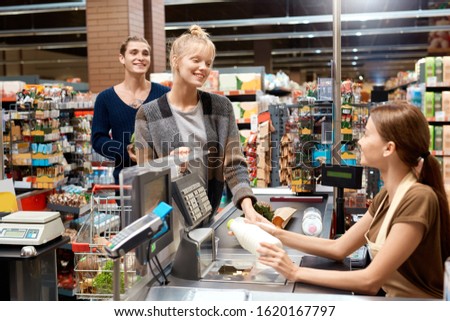 Young couple at the supermarket doing daily shoppings checkout at cashier counter smiling happy Royalty-Free Stock Photo #1620167797