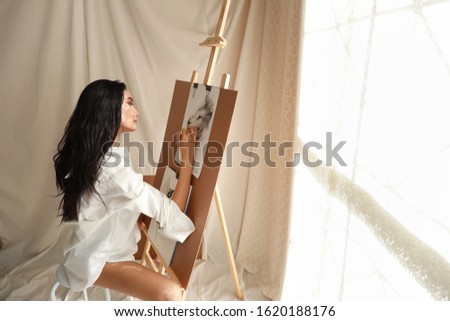 side view woman artist in white shirt drawing picture with pencil (woman lifestyle concept)
