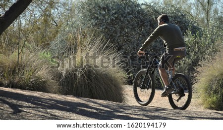 Man Riding Bike During the Winter in a Riparian Park 