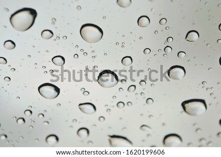 Rain drops on the car glass with blurred background. Selective focus.