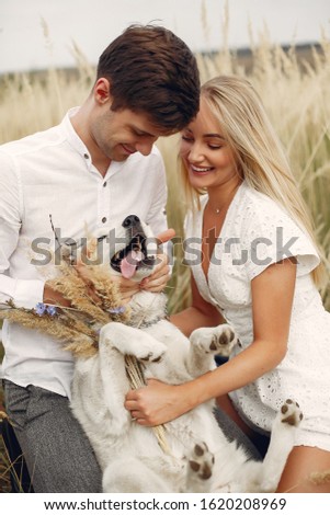 Couple in a field. Pair with a dog. Girl in a white dress