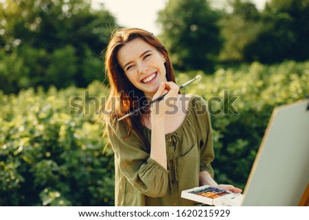 Woman in a summer field. Cute lady drawing. Girl with colorful paints