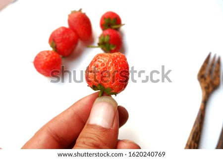 A strawberry on the hand
