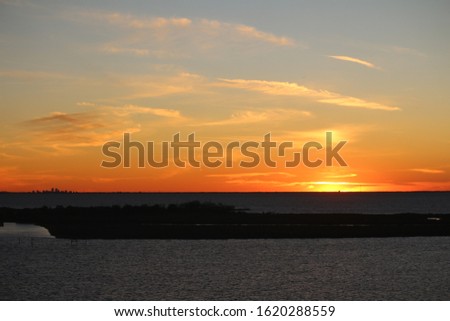 New Orleans skyline as sunsets on the horizon. Picture taken from the north shore of Lake Pontchartrain in Slidell, Louisiana.