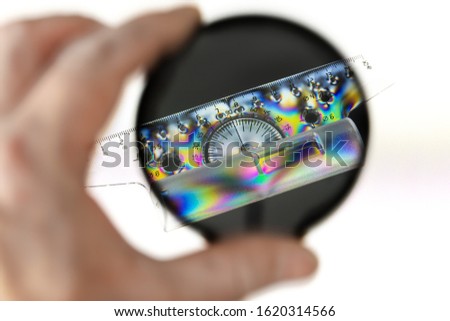 Transparent plastic protractor with ruler, photographed through a polarizing filter with a polarized light source. Royalty-Free Stock Photo #1620314566