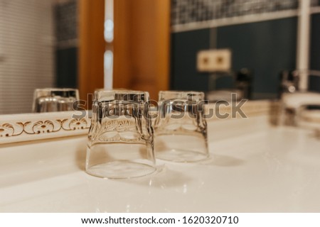 empty glass inverted glasses in the bathroom for rinsing teeth after cleaning, bathroom interior