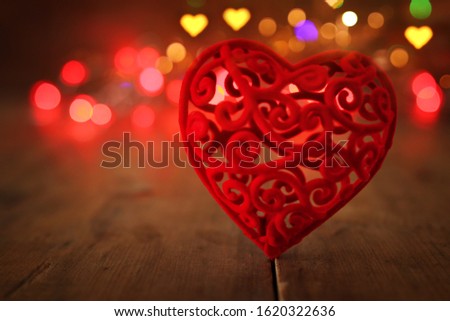Valentines day concept. one heart over wooden background and glitter lights