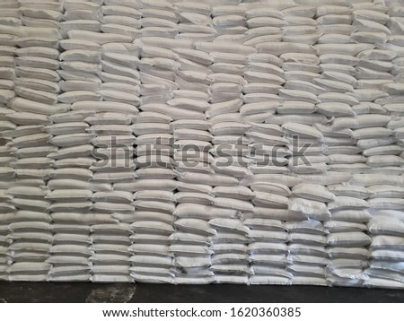 The product stock is packed in sacks, stacked in the warehouse, waiting for delivery.