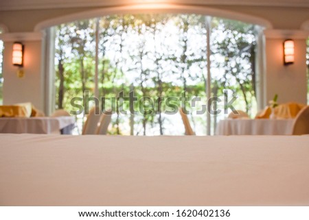 Blurred image inside the banquet room, Blurred soft of people meeting, Blurred image of stage with rear view of audience in the conference hall or seminar meeting