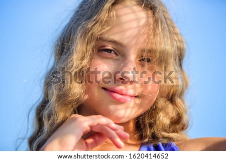 Take care skin put sunscreen cosmetics. Girl kid relaxing outdoors. Uv filter sunscreen. Take care. Summer care. Sunscreen concept. Child pleased with warm sunlight looks relaxed blue sky background.