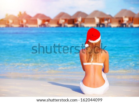 New Year celebration on Maldives, travel on winter holidays to summer destinations, back side, wearing red Santa Claus hat