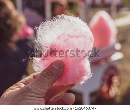 Sweet red cotton candy in the hand.