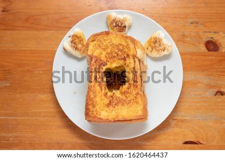Toast on a white plate on a wooden table.