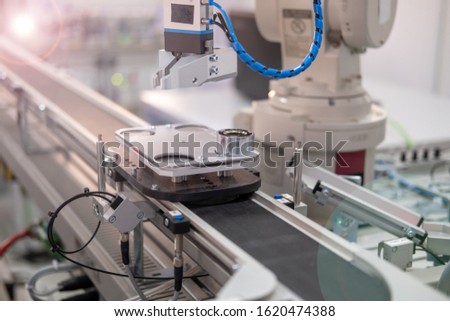 Close-up of a robot arm's gripper. Industry 4.0 concept; artificial intelligence in smart factory. Robot picks up the product from automated car on the manufacturing line. Selective focus.