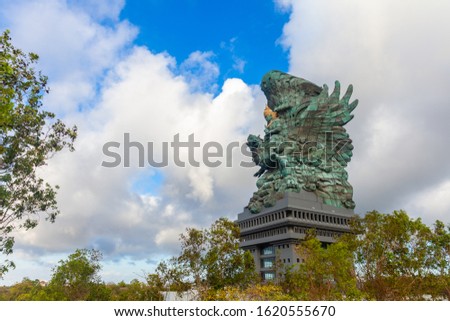 Landscape picture of old Garuda Wisnu Kencana GWK statue as Bali landmark with blue sky as a background. Balinese traditional symbol of hindu religion. Popular travel destinations in Indonesia.