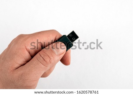 USB memory stick in male hand on white background with copy space. Data, information, security and technology