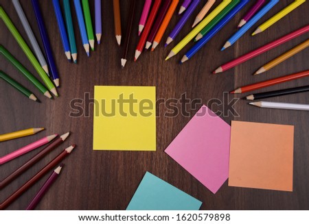 Yellow stick note paper on the table stock images. Crayons on a wooden background. Set of colored pencils. School supplies for drawing. Art supplies. Blank note paper. Office supply stock images